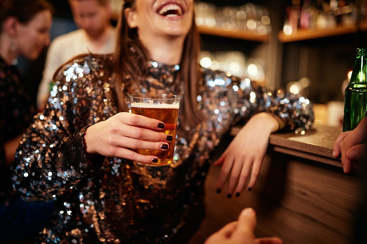 woman laughing in bar while drinking making others wonder Is My Loved One an Alcoholic