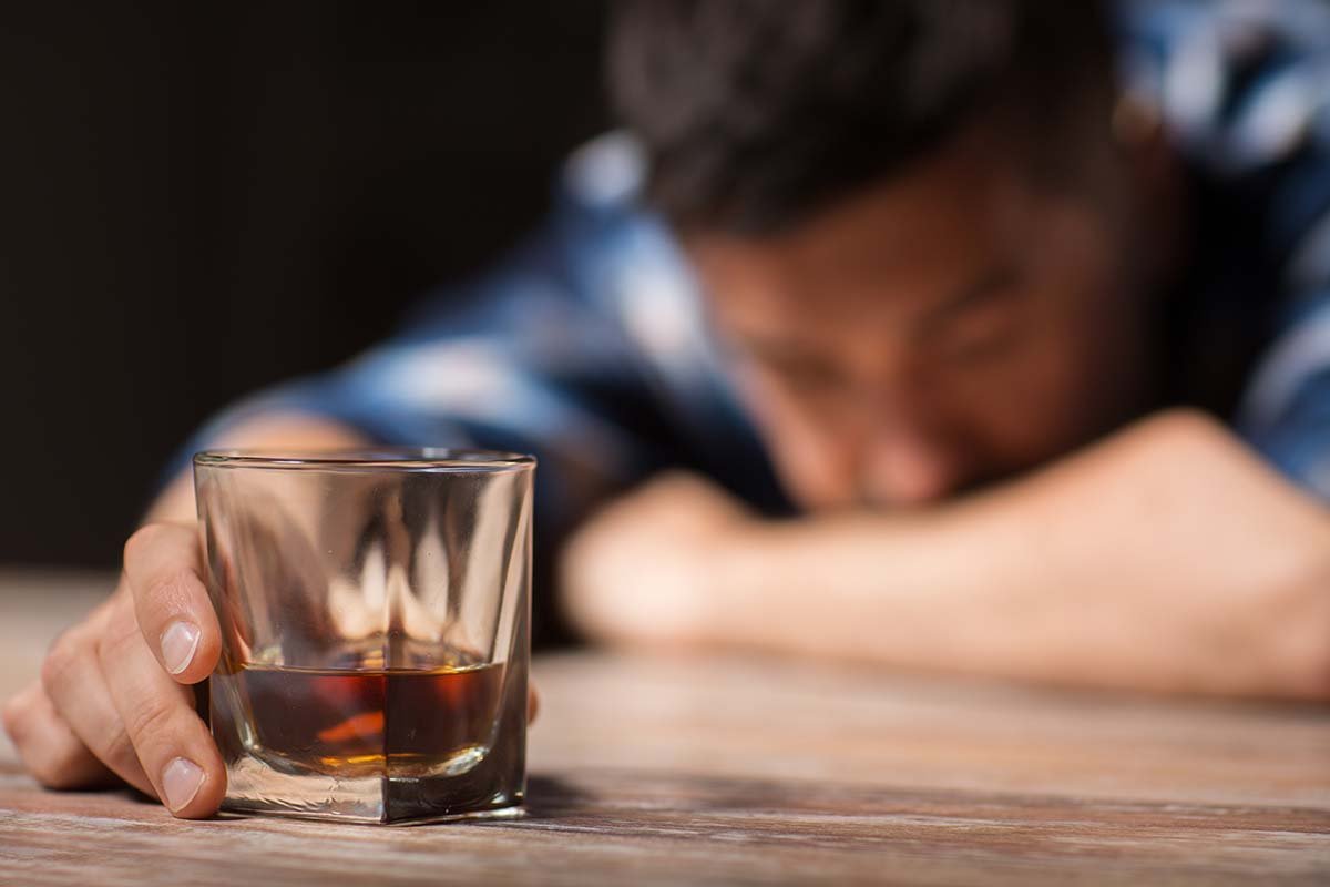 a man struggles with the signs of alcohol addiction