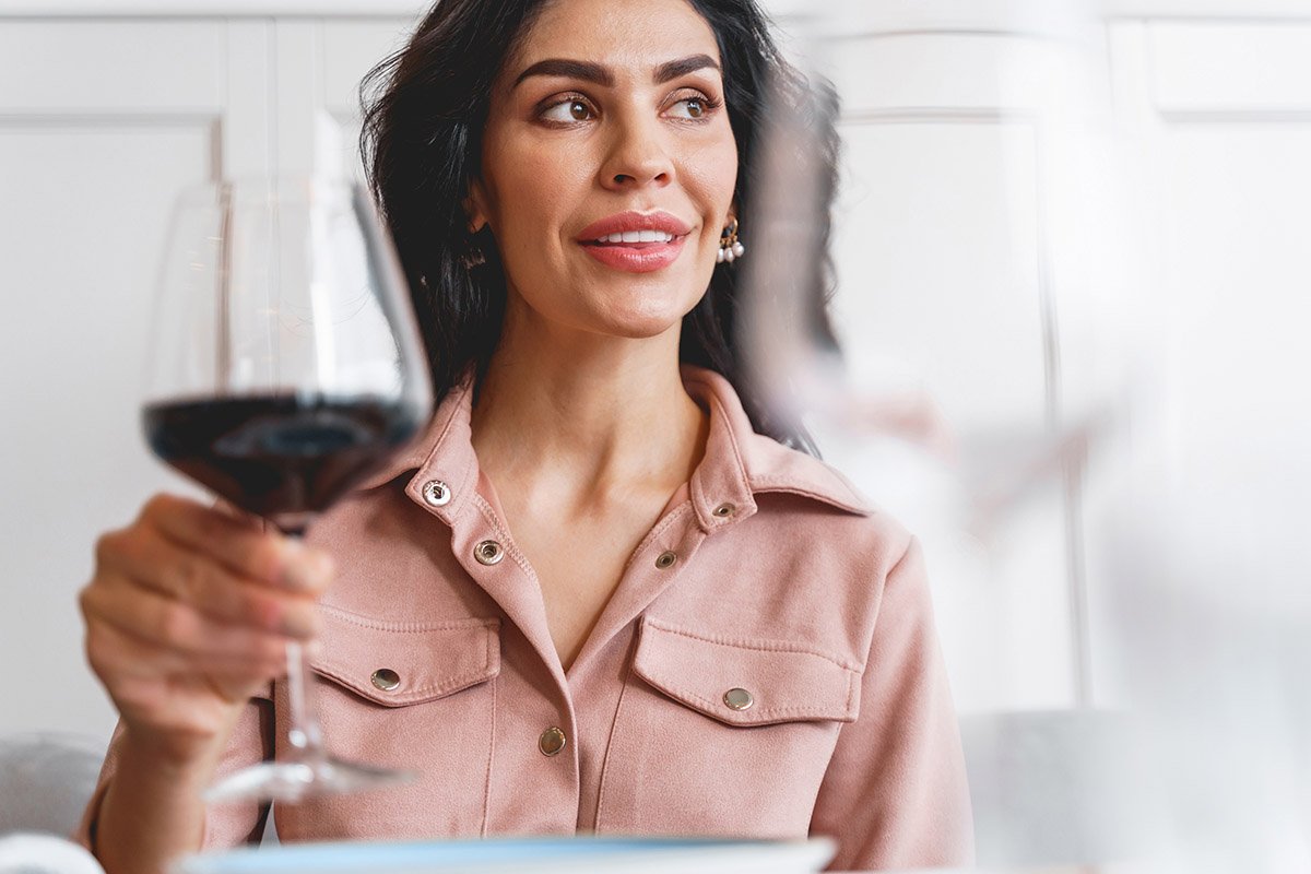 woman holding large glass of red wine part of wine mom culture